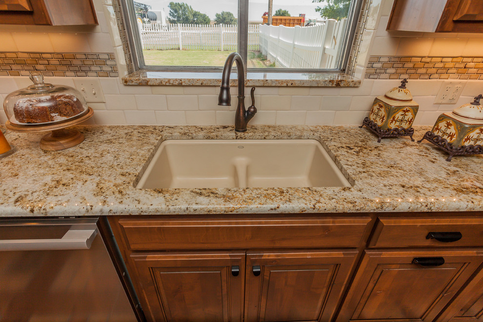 Example of a large mountain style l-shaped brick floor home design design in Dallas with a double-bowl sink, raised-panel cabinets, medium tone wood cabinets, granite countertops, beige backsplash, ceramic backsplash, stainless steel appliances and two islands