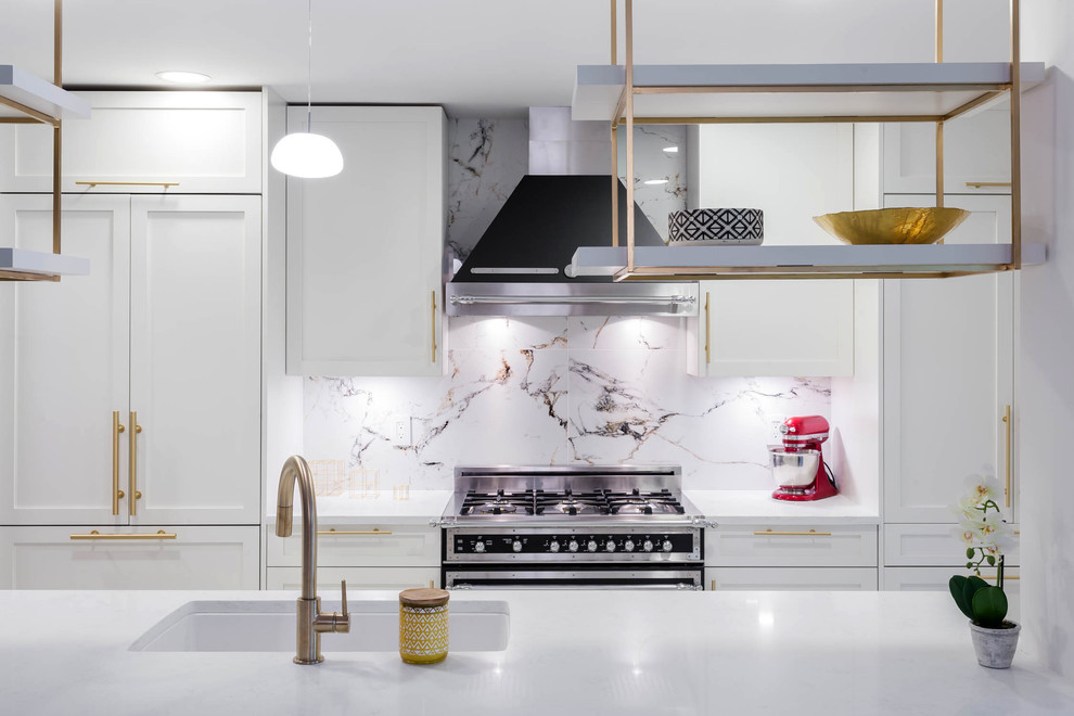 A kitchen with white shaker cabinets and Gold / Brass ...