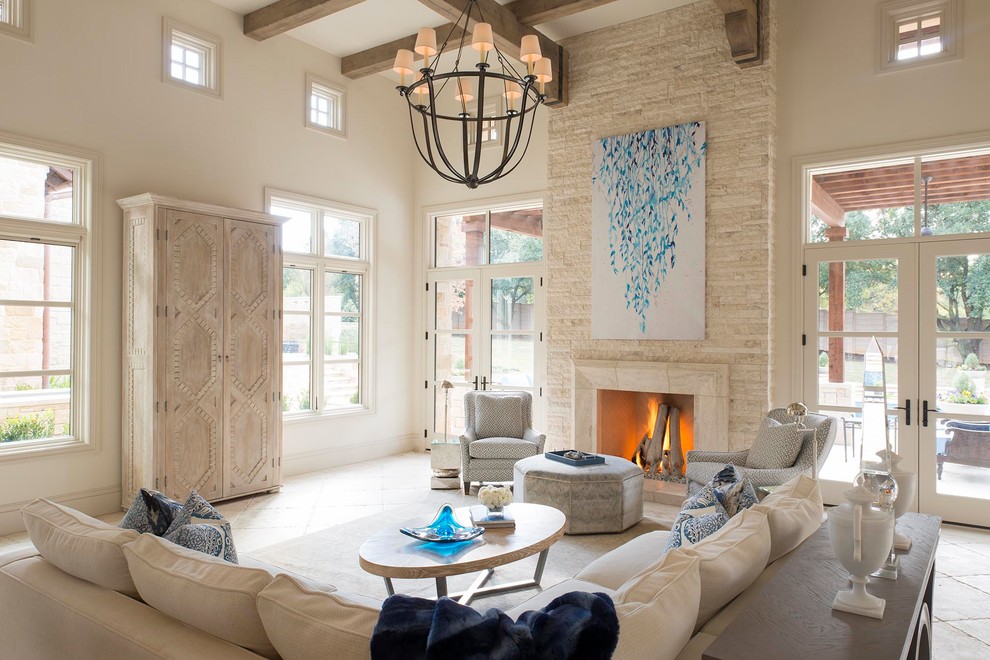 Design ideas for a beach style living room in Dallas with white walls, a standard fireplace, a stone fireplace surround and beige floor.