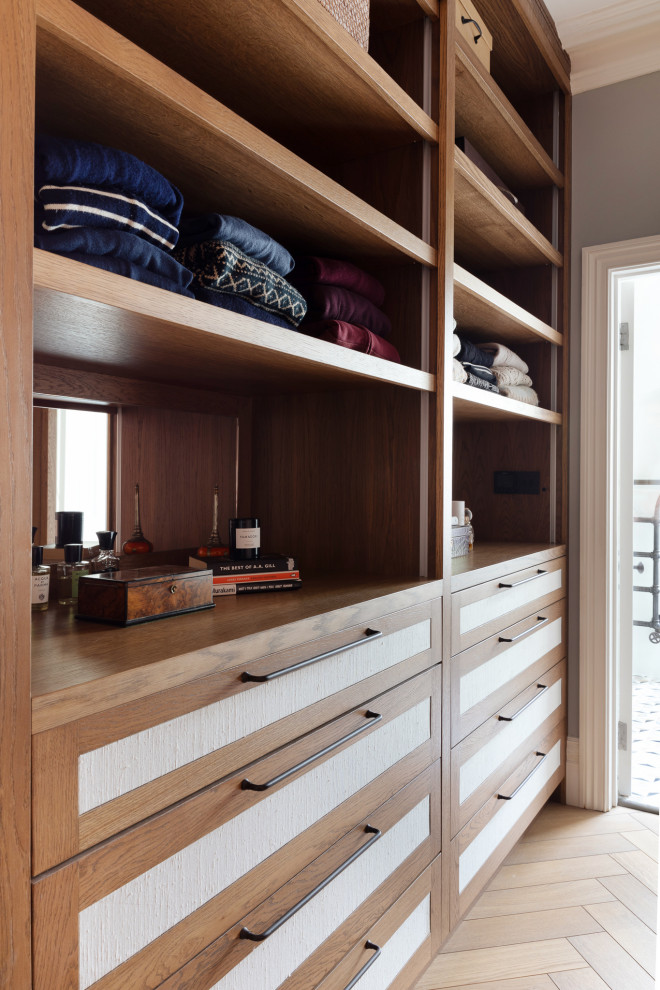 Mid-sized contemporary gender-neutral dressing room in London with recessed-panel cabinets, medium wood cabinets, medium hardwood floors, beige floor and coffered.