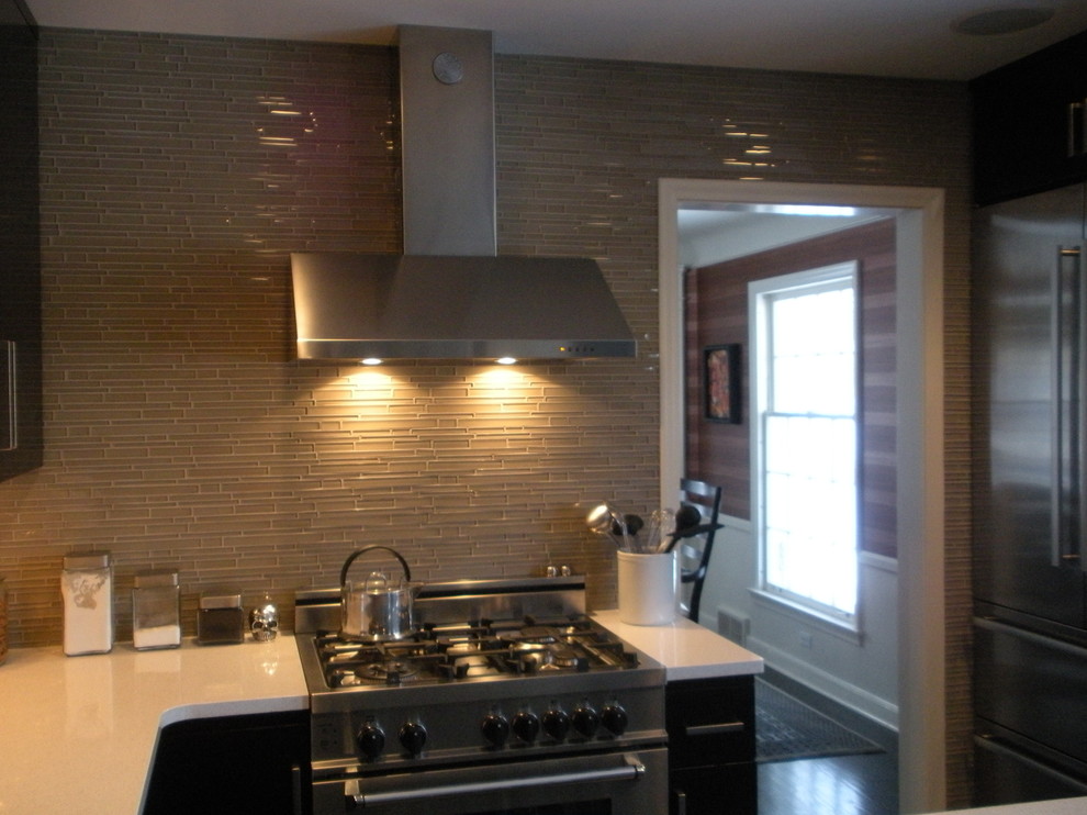 Transitional kitchen photo with gray backsplash and stainless steel appliances