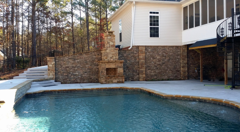 This is an example of a small traditional backyard custom-shaped natural pool in Atlanta with concrete slab.