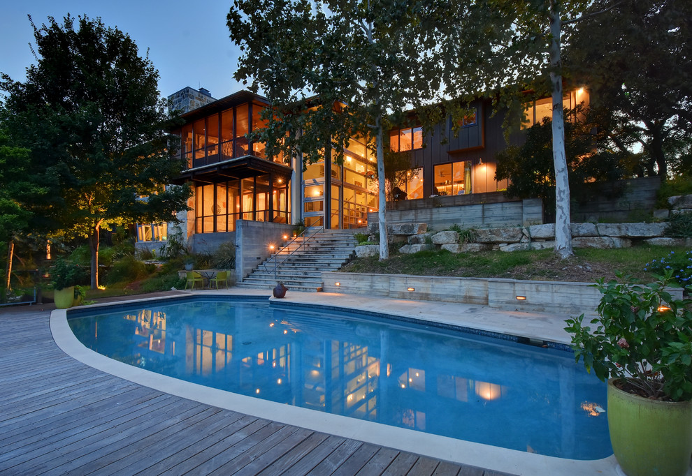 Contemporary backyard custom-shaped pool in Austin with decking.