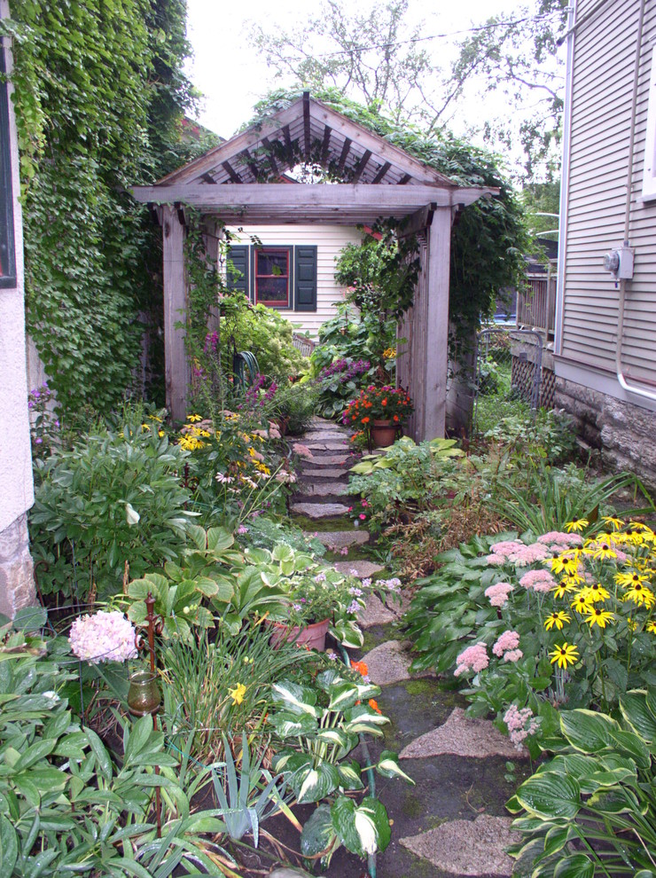 Inspiration for a mid-sized contemporary backyard partial sun formal garden for summer in Minneapolis with a garden path and natural stone pavers.