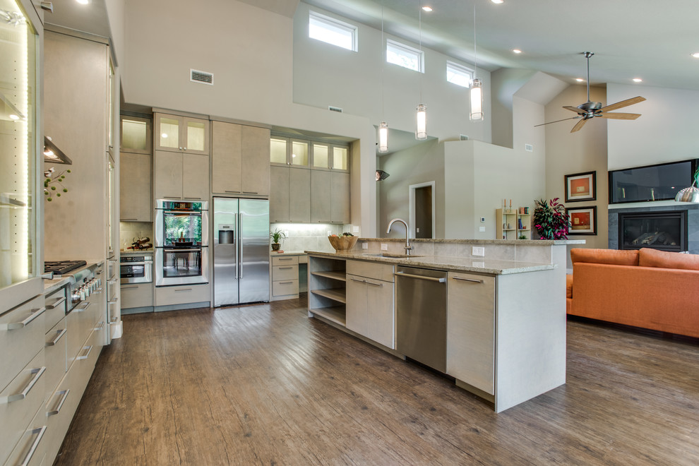Photo of a large contemporary u-shaped open plan kitchen in Dallas with an undermount sink, flat-panel cabinets, white cabinets, granite benchtops, stainless steel appliances, medium hardwood floors, a peninsula and brown floor.