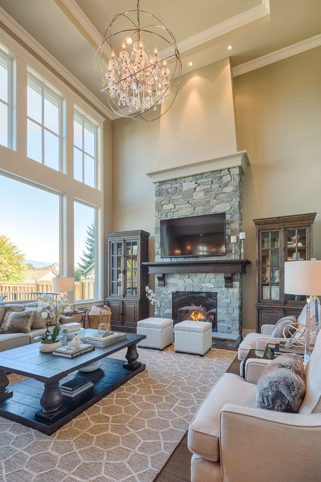 Photo of a mid-sized traditional open concept living room in Vancouver with beige walls, dark hardwood floors, a standard fireplace, a stone fireplace surround and a wall-mounted tv.
