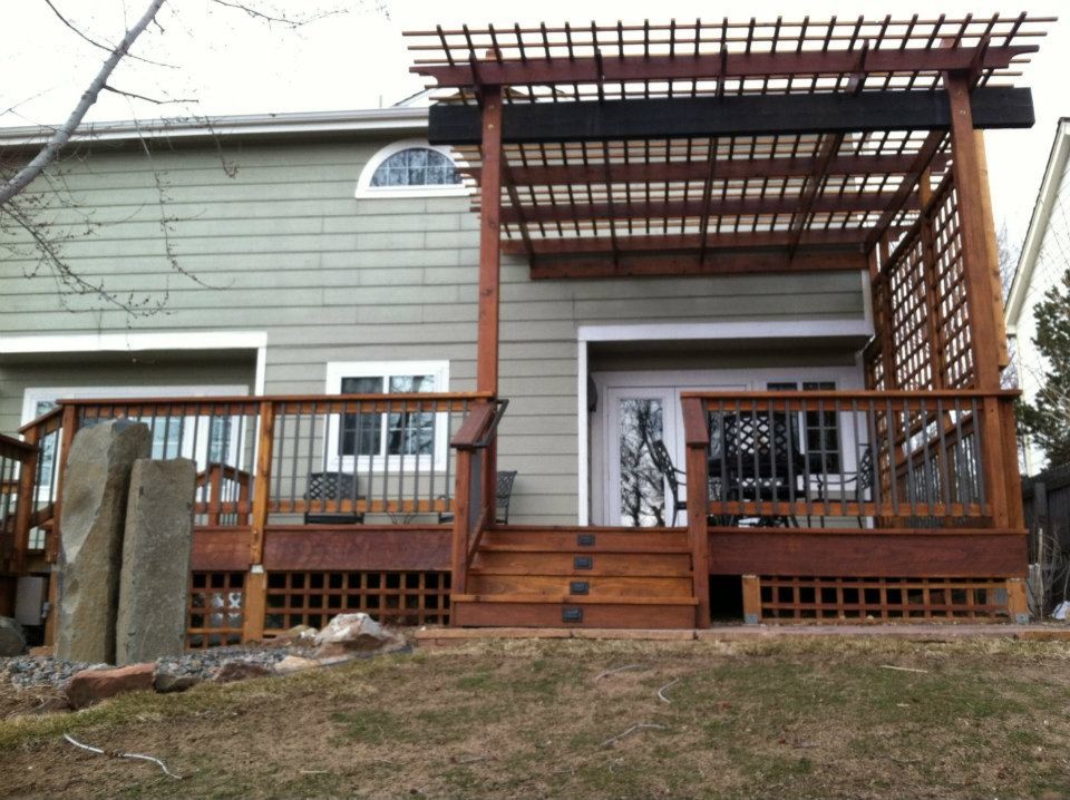 This is an example of a mid-sized backyard deck in Denver with a water feature and a pergola.