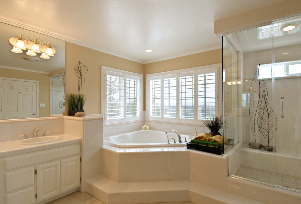 Inspiration for a large traditional master bathroom in Atlanta with raised-panel cabinets, beige cabinets, a drop-in tub, an alcove shower, beige walls, marble benchtops, beige floor, a hinged shower door, beige benchtops, a built-in vanity, recessed and wood walls.