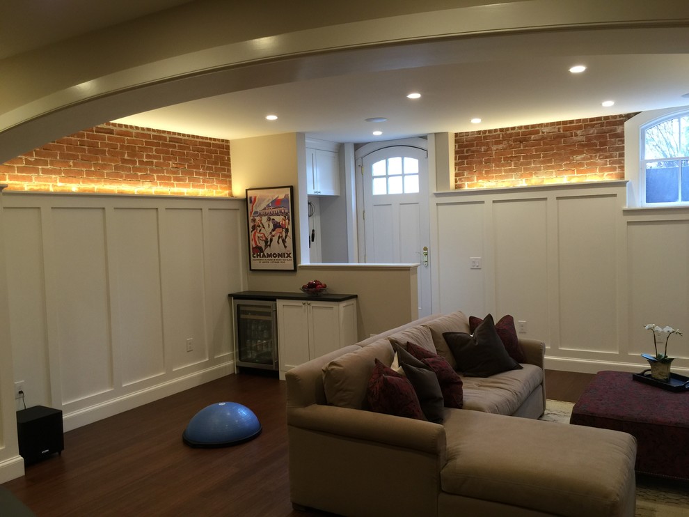 Design ideas for a mid-sized traditional walk-out basement in Providence with white walls, bamboo floors, a standard fireplace and a brick fireplace surround.