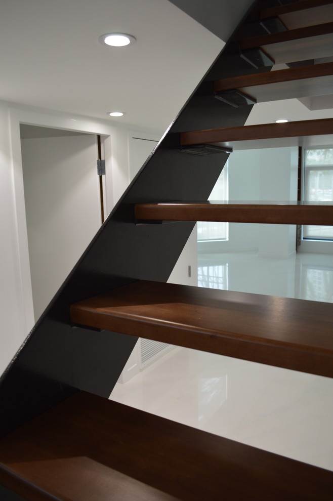 This is an example of a large contemporary wood floating staircase in San Diego with open risers.
