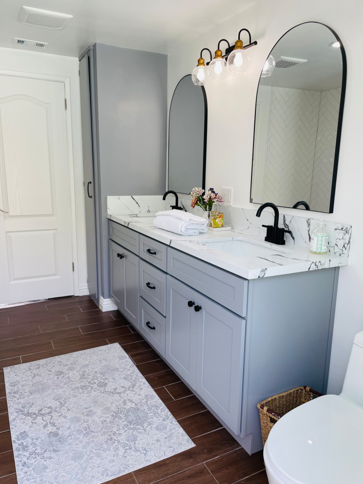 Medium sized country grey and black family bathroom in Los Angeles with shaker cabinets, grey cabinets, an alcove shower, a one-piece toilet, white tiles, porcelain tiles, white walls, porcelain flooring, a submerged sink, engineered stone worktops, brown floors, a hinged door, black worktops, double sinks and a built in vanity unit.