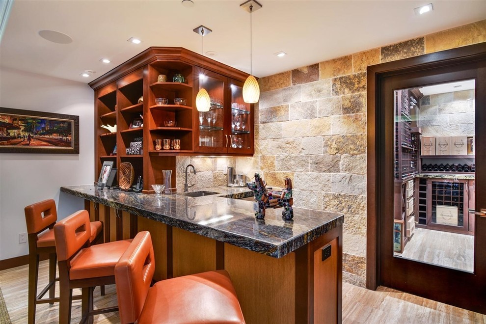 Contemporary seated home bar in San Diego with an undermount sink, glass-front cabinets, medium wood cabinets, multi-coloured splashback, stone tile splashback, beige floor and multi-coloured benchtop.