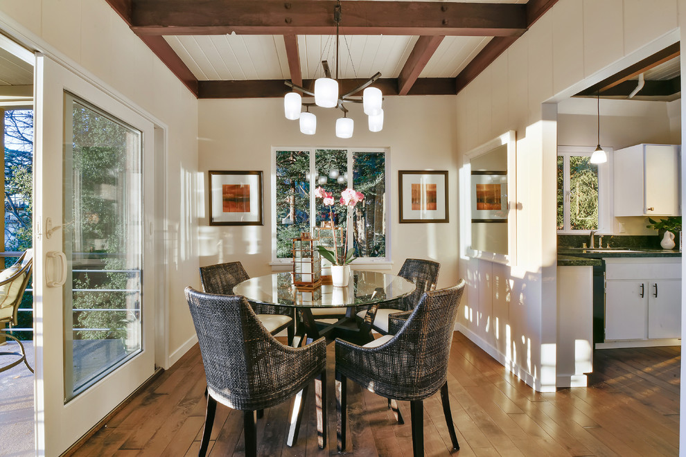 Photo of a mid-sized contemporary open plan dining in Other with white walls, medium hardwood floors, a standard fireplace and a brick fireplace surround.