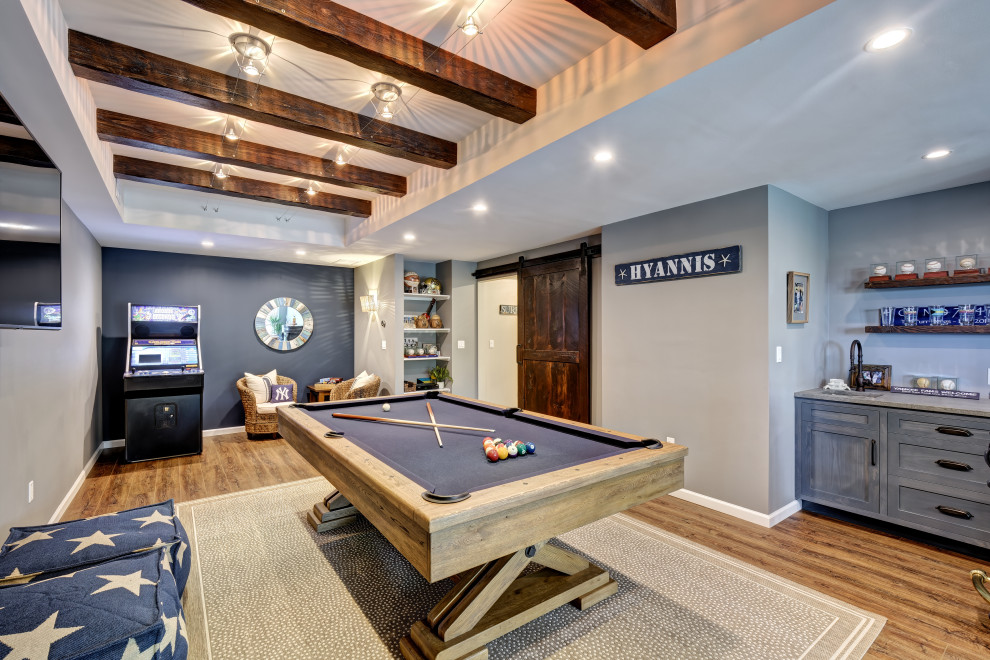 Large beach style walk-out basement in New York with a home bar, blue walls, vinyl floors, no fireplace, brown floor, exposed beam and planked wall panelling.