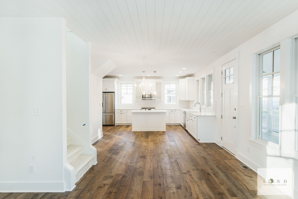 Mid-sized arts and crafts l-shaped dark wood floor and shiplap ceiling open concept kitchen photo in Indianapolis with a farmhouse sink, white cabinets, white backsplash, stainless steel appliances, an island and white countertops