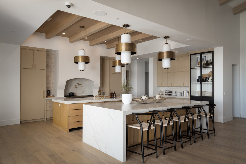 Design ideas for a large transitional galley open plan kitchen in Phoenix with an undermount sink, beaded inset cabinets, light wood cabinets, quartz benchtops, white splashback, stone slab splashback, stainless steel appliances, light hardwood floors, multiple islands, beige floor, white benchtop and wood.