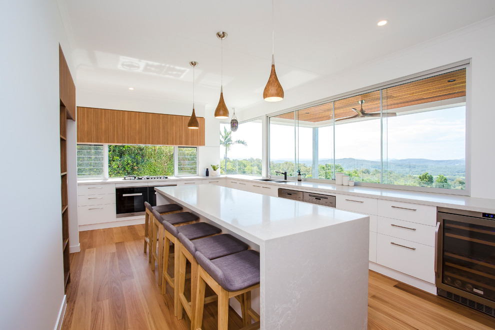 Inspiration for a large contemporary l-shaped separate kitchen in Sunshine Coast with a double-bowl sink, flat-panel cabinets, white cabinets, quartz benchtops, window splashback, stainless steel appliances, light hardwood floors, with island and brown floor.