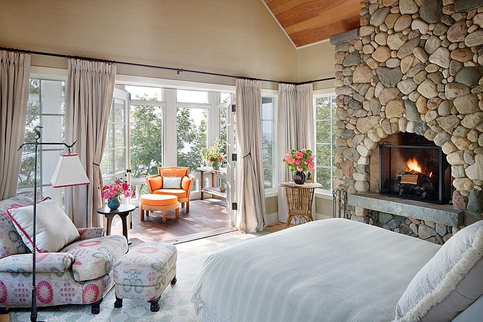 Country bedroom in Chicago with a stone fireplace surround and a standard fireplace.