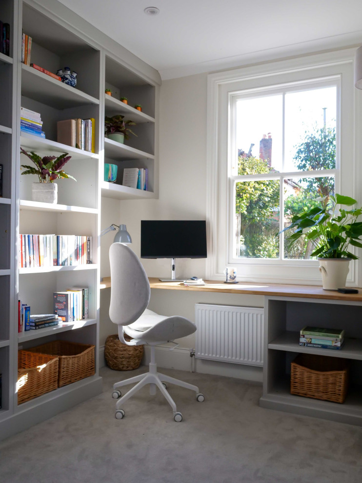 Réalisation d'un petit bureau minimaliste avec un mur blanc, moquette, un bureau intégré et un sol gris.