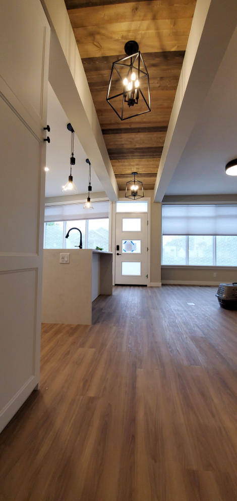 Cette photo montre un couloir nature de taille moyenne avec un mur blanc, un sol en vinyl, un sol marron et un plafond en bois.