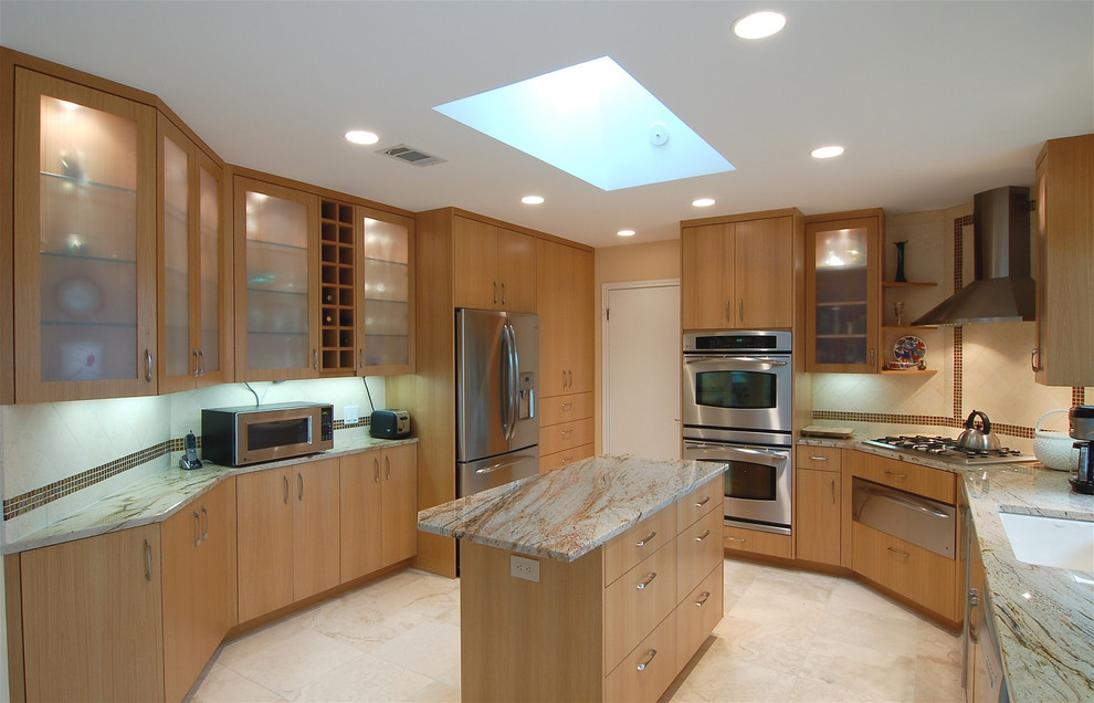 This is an example of a mid-sized contemporary u-shaped open plan kitchen in Austin with an undermount sink, flat-panel cabinets, light wood cabinets, granite benchtops, beige splashback, stone tile splashback, stainless steel appliances, travertine floors and with island.