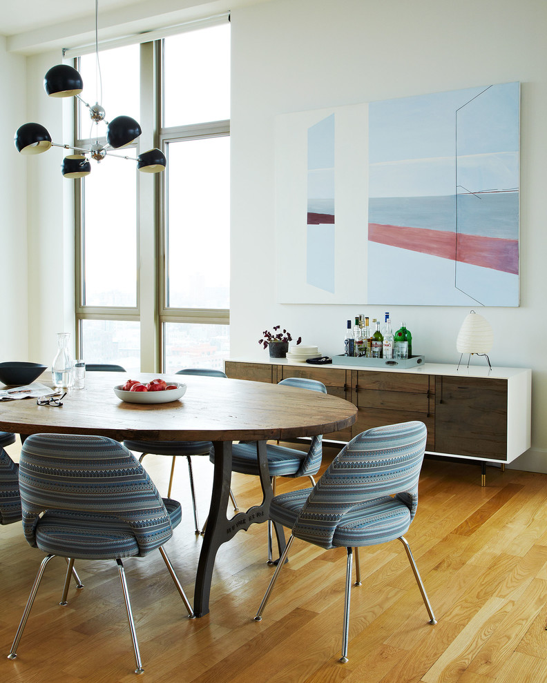 Inspiration for a scandinavian dining room in New York with white walls and medium hardwood floors.