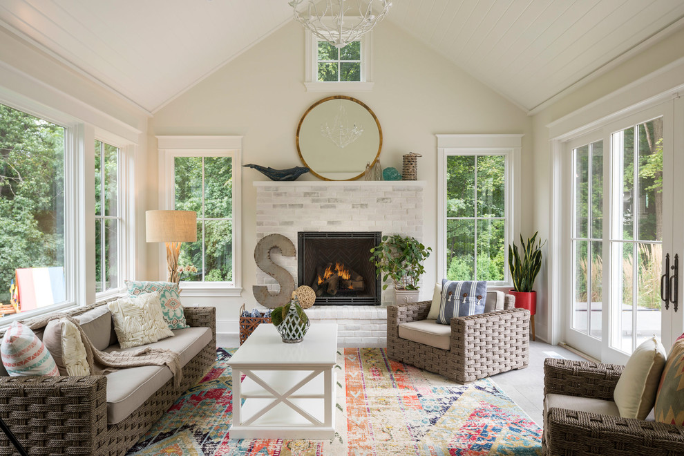 Photo of a mid-sized beach style sunroom in Minneapolis with a standard fireplace, a standard ceiling, grey floor, travertine floors and a brick fireplace surround.