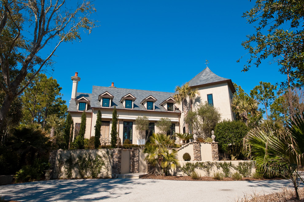 Inspiration for a large traditional two-storey stucco beige exterior in Charleston with a gable roof.