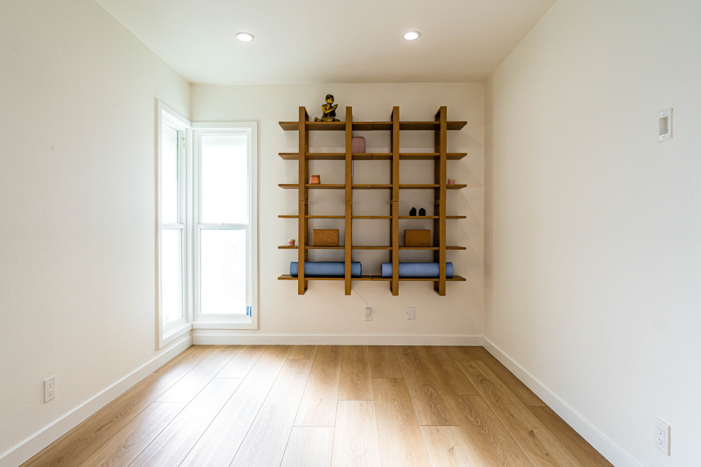 Cette photo montre une chambre d'amis tendance en bois avec un mur blanc, parquet clair, un sol marron et poutres apparentes.