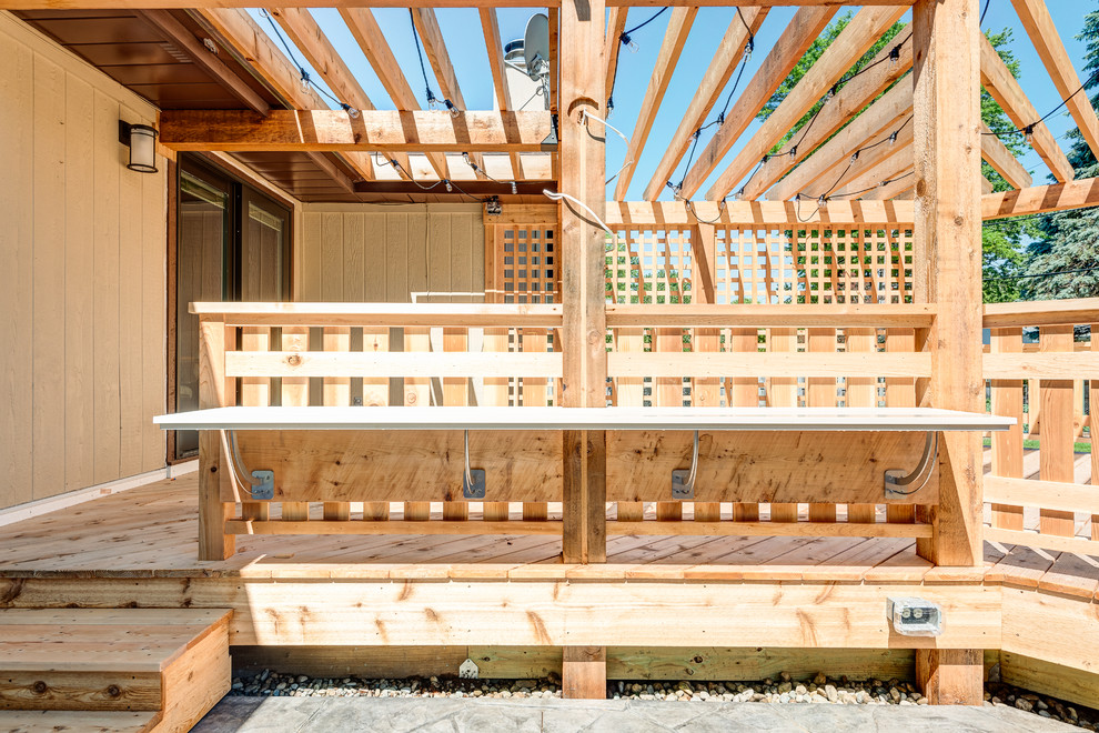 Example of a large transitional backyard deck design in Chicago with a pergola