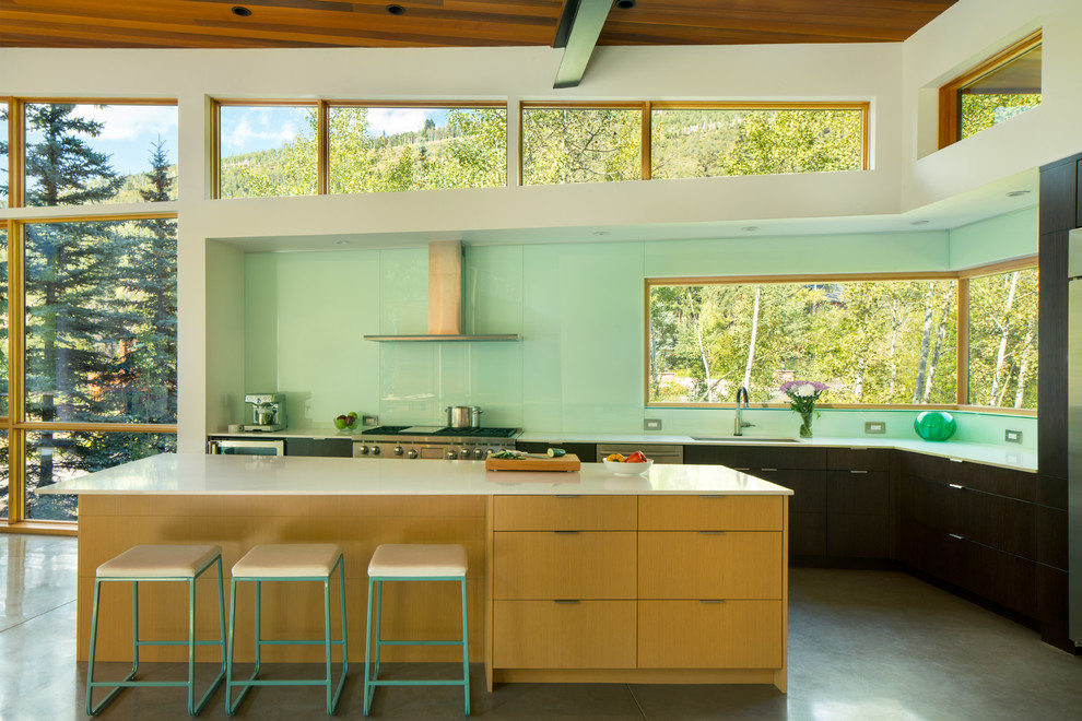Inspiration for a mid-sized contemporary l-shaped eat-in kitchen in Denver with an undermount sink, flat-panel cabinets, stainless steel appliances, concrete floors, with island, dark wood cabinets, blue splashback and stone slab splashback.