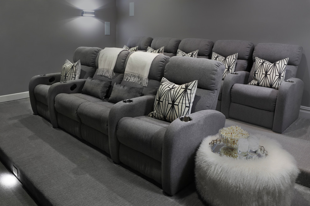 This is an example of a mid-sized transitional open concept home theatre in New York with grey walls and carpet.