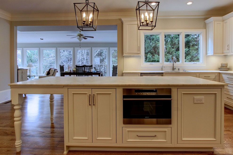 Large transitional u-shaped light wood floor kitchen pantry photo in Atlanta with an undermount sink, recessed-panel cabinets, white cabinets, quartz countertops, white backsplash, subway tile backsplash, stainless steel appliances and an island