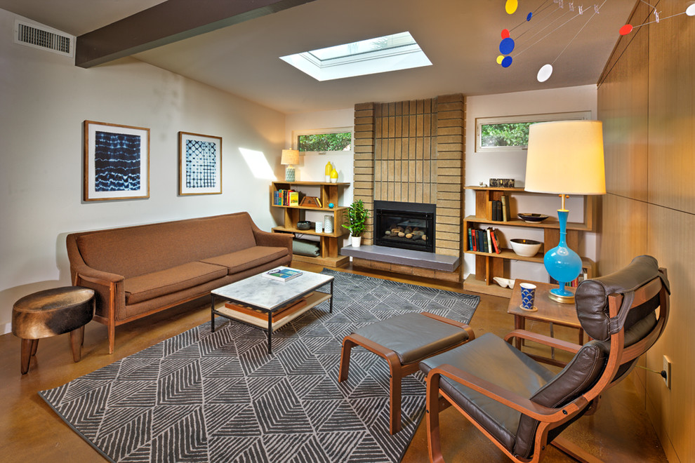 Design ideas for a mid-sized midcentury open concept living room in Sacramento with a library, white walls, concrete floors, a standard fireplace, a brick fireplace surround, a built-in media wall and brown floor.