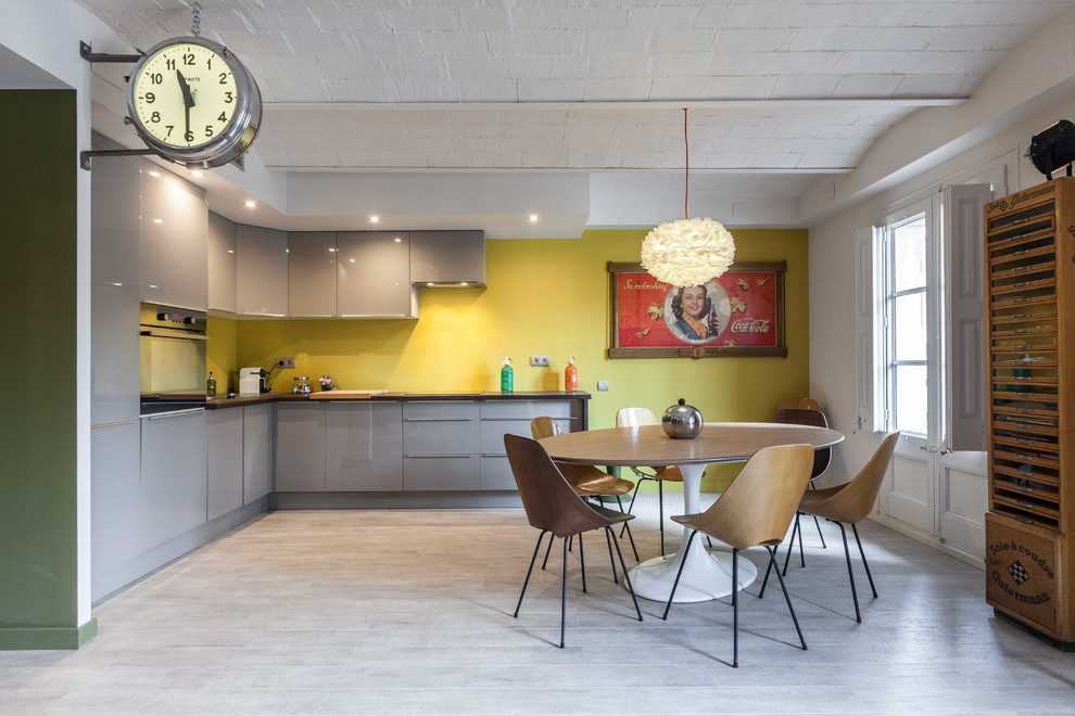 Design ideas for a large eclectic l-shaped eat-in kitchen in Barcelona with flat-panel cabinets, grey cabinets, yellow splashback and no island.