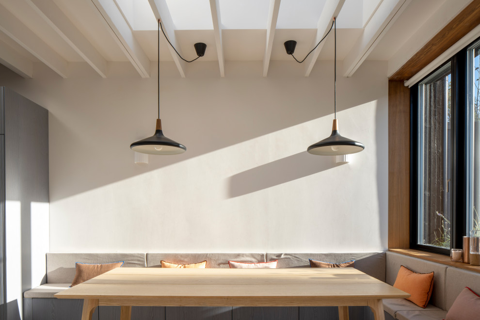 Cette photo montre une salle à manger tendance de taille moyenne avec une banquette d'angle, un mur blanc, un sol en marbre, un sol blanc et un plafond à caissons.