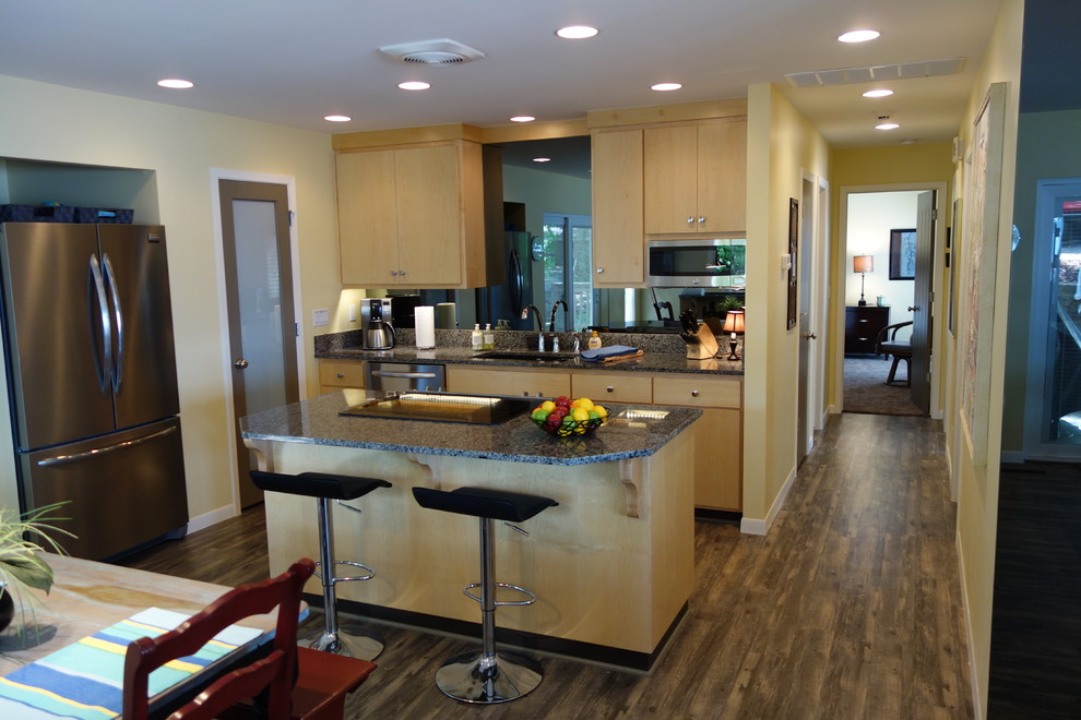 This is an example of a small modern single-wall eat-in kitchen in Other with an undermount sink, flat-panel cabinets, light wood cabinets, granite benchtops, stainless steel appliances, linoleum floors and with island.