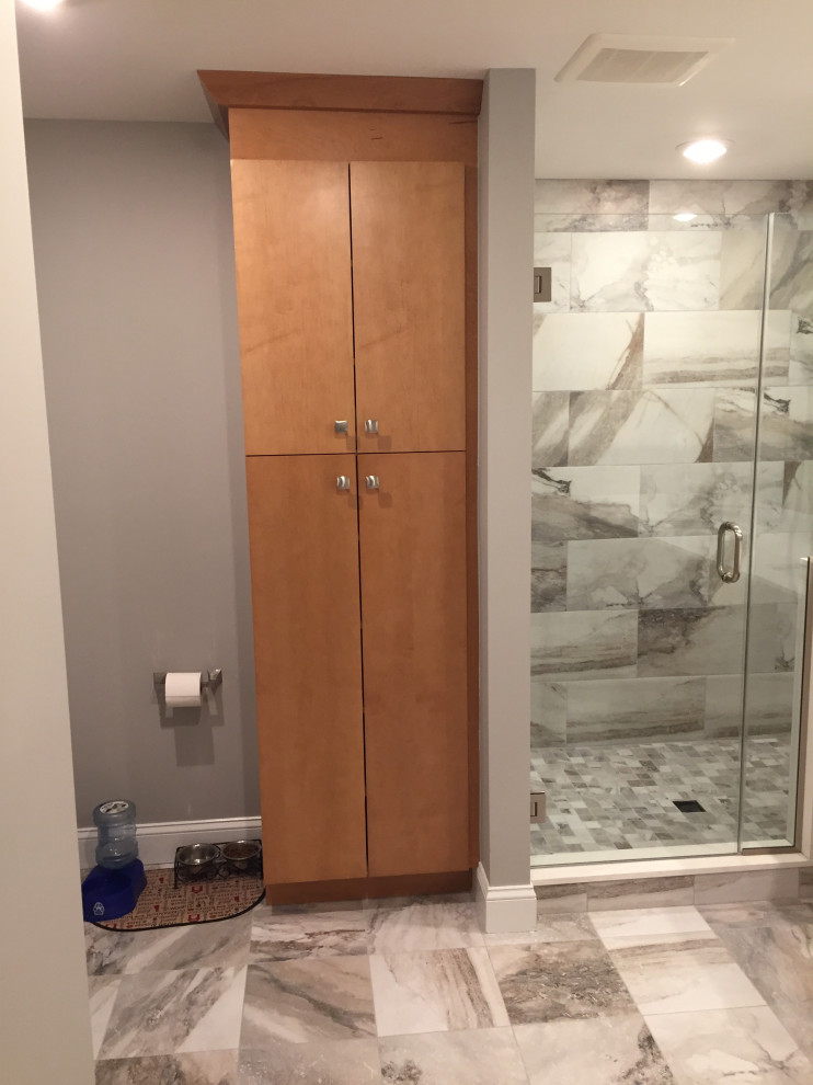 Photo of a medium sized contemporary ensuite bathroom in Philadelphia with flat-panel cabinets, medium wood cabinets, an alcove shower, a two-piece toilet, grey tiles, marble tiles, beige walls, marble flooring, a submerged sink, engineered stone worktops, a sliding door, white worktops and a built in vanity unit.