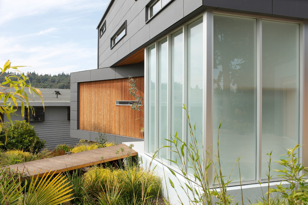 Design ideas for a mid-sized modern two-storey grey exterior in Seattle with wood siding and a flat roof.