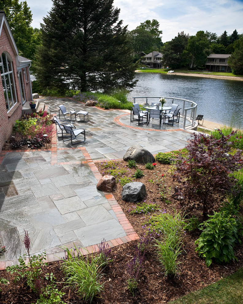 Mid-sized contemporary backyard full sun garden in Milwaukee with natural stone pavers for summer.