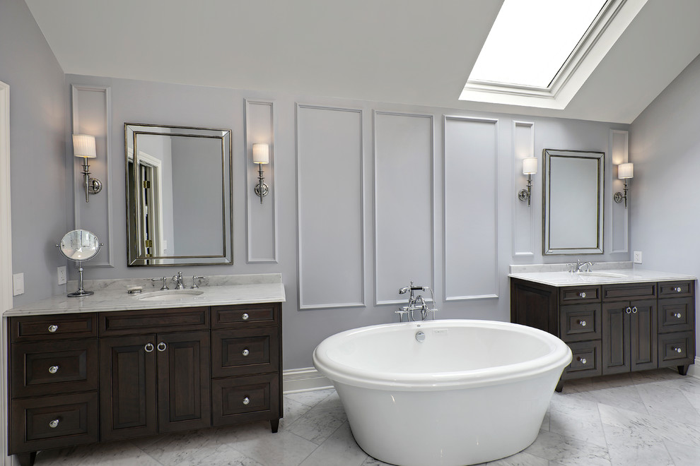 Elegant master gray floor freestanding bathtub photo in Chicago with dark wood cabinets, gray walls, an undermount sink, gray countertops and raised-panel cabinets