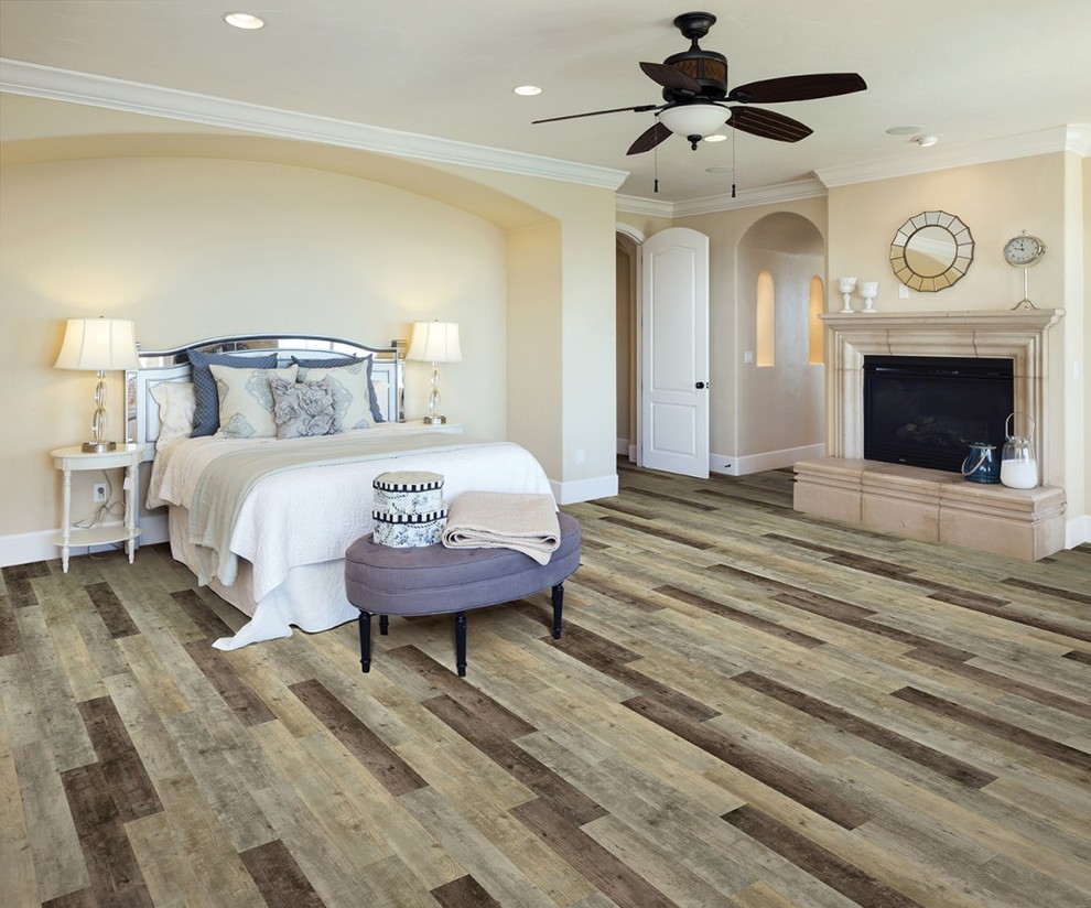 Design ideas for a large traditional master bedroom in San Diego with yellow walls, vinyl floors, a standard fireplace and a stone fireplace surround.