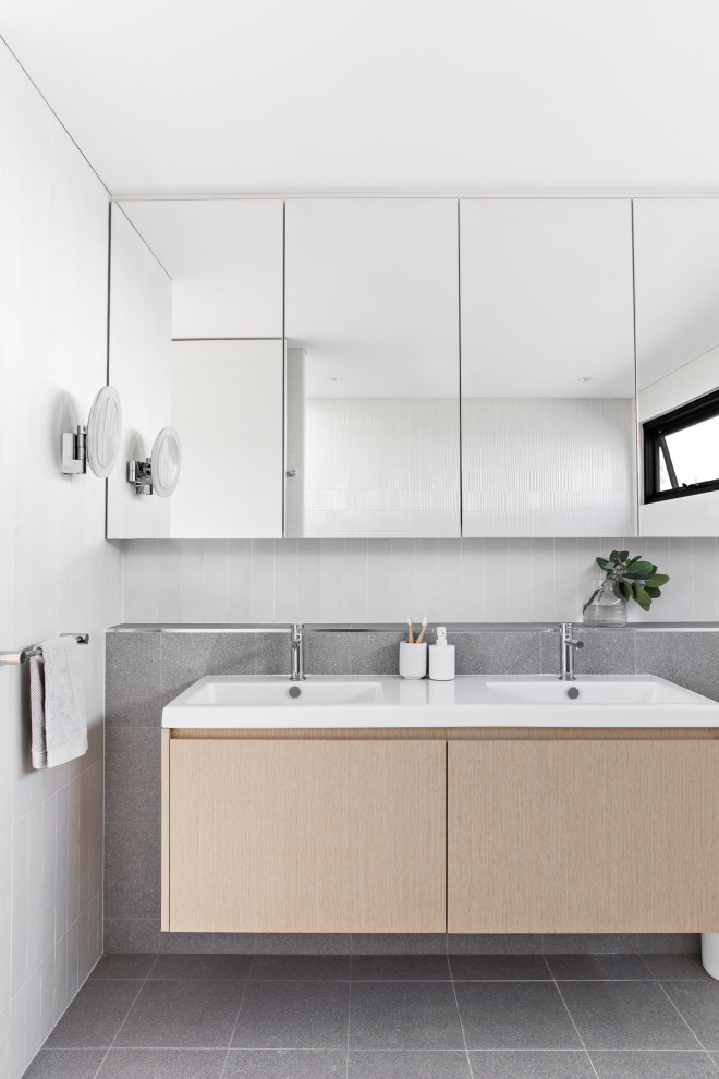 This is an example of a mid-sized contemporary master bathroom in Sydney with light wood cabinets, white tile, gray tile, ceramic tile, white walls, porcelain floors, grey floor, a double vanity, a floating vanity, flat-panel cabinets, an integrated sink and white benchtops.