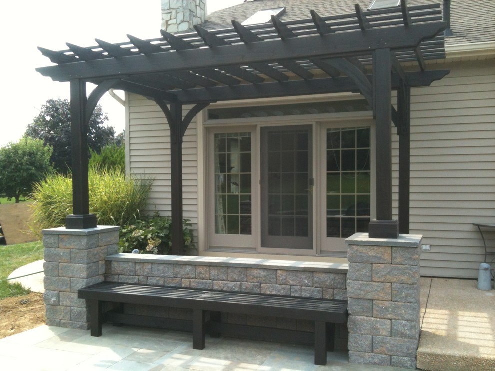 Mid-sized arts and crafts backyard patio in Philadelphia with natural stone pavers and a pergola.