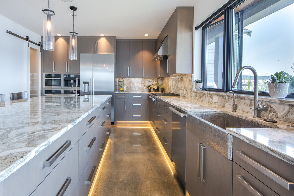 Inspiration for a contemporary l-shaped kitchen in Seattle with a farmhouse sink, flat-panel cabinets, grey cabinets, stainless steel appliances, concrete floors, with island, grey floor, beige benchtop and quartzite benchtops.