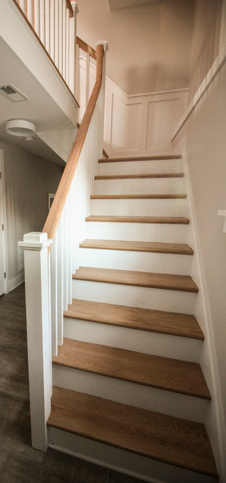 Photo of a large traditional wood l-shaped staircase in DC Metro with wood risers and wood railing.