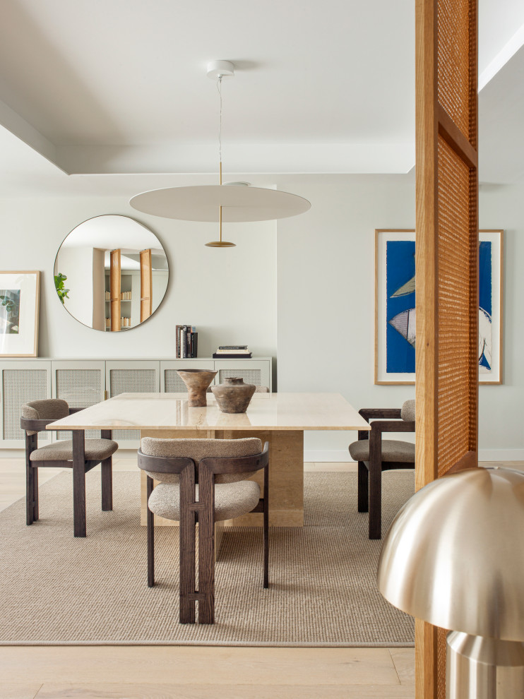 Ispirazione per una sala da pranzo aperta verso il soggiorno chic con pareti bianche, parquet chiaro e pavimento beige