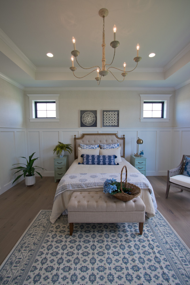 This is an example of a master bedroom in Other with light hardwood floors, brown floor, coffered and decorative wall panelling.