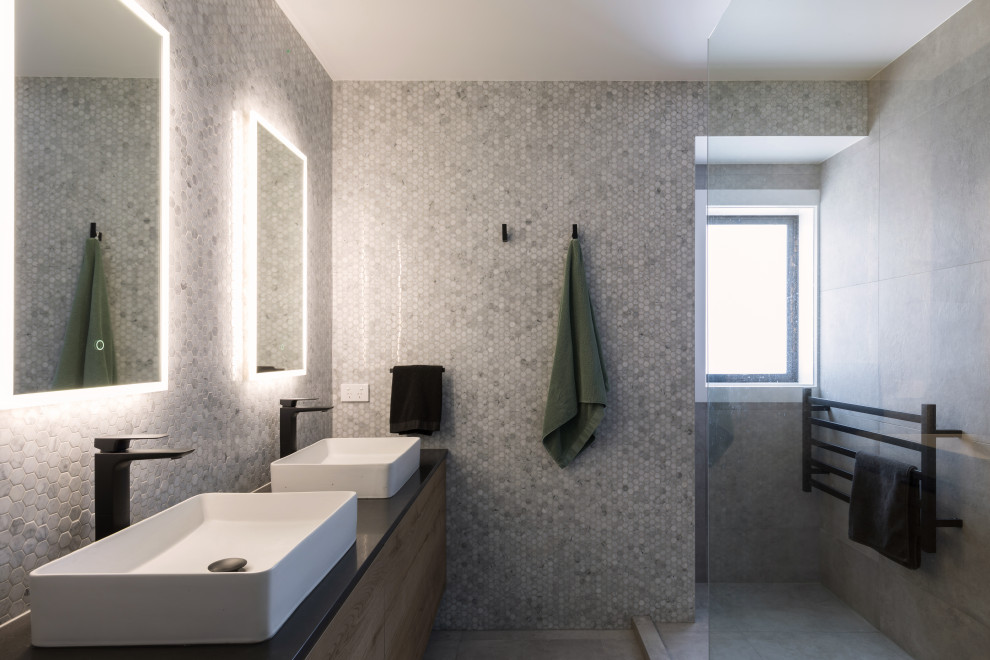 Foto di una stanza da bagno padronale contemporanea di medie dimensioni con ante in legno scuro, piastrelle a mosaico, top in quarzo composito, top nero, due lavabi e mobile bagno sospeso