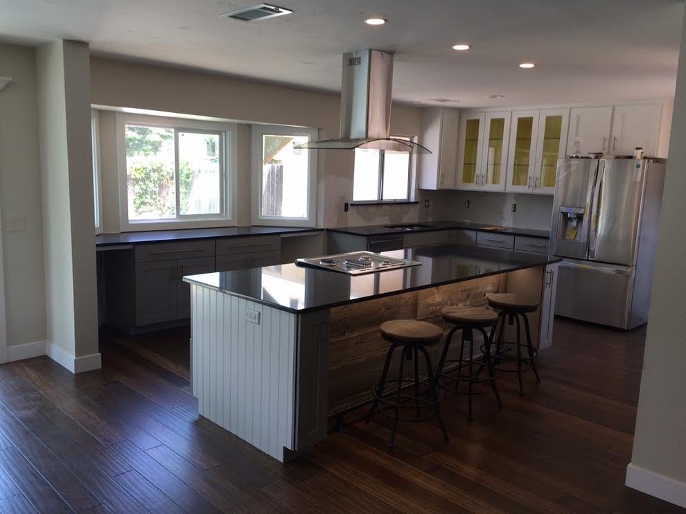 Mid-sized transitional l-shaped dark wood floor kitchen photo in Sacramento with shaker cabinets, stainless steel appliances, an island and gray cabinets